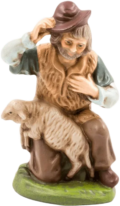 Kneeling shepherd figure holding a sheep, hand-painted papier-mâché with brown hat and green base
