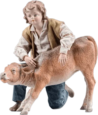 Hand-carved wooden figure of a boy kneeling with a calf, dressed in fabric clothing, painted details
