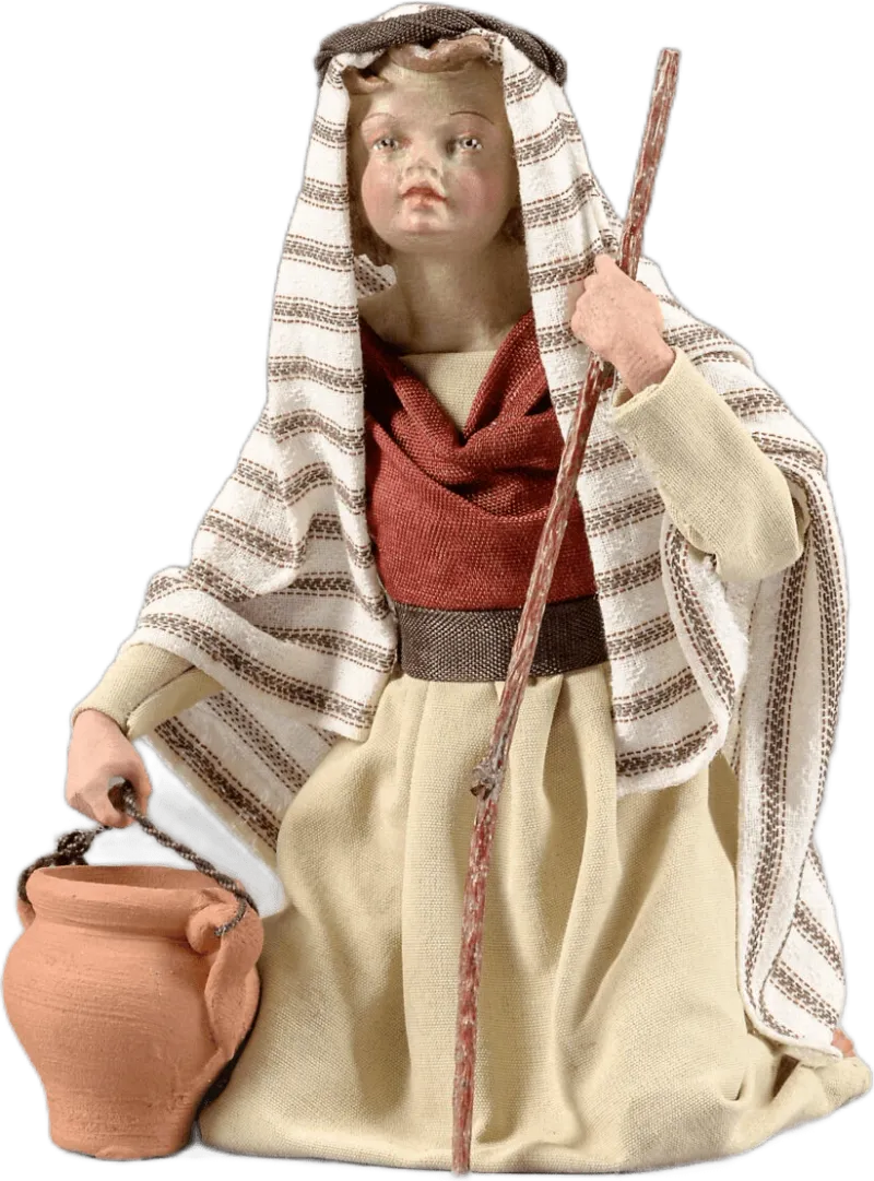 Hand-carved wooden Boy figure kneeling, dressed in striped fabric cloak and holding clay pot and staff